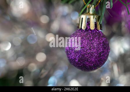 Ornamento viola dell'albero di Natale su sfondo sfocato appeso all'albero di Natale Foto Stock