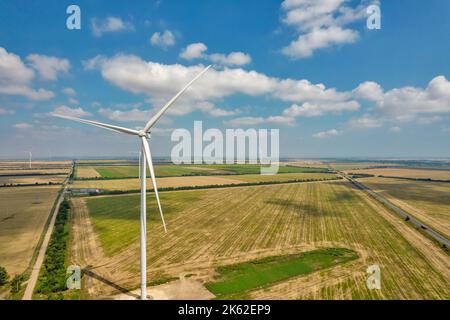 Vista del drone sopra la turbina della fattoria eolica primo piano contro il cielo blu con le nuvole. Foto Stock