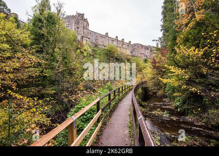 Castello di Skipton, dal sentiero pedonale a Skipton Woods, che mostra alcuni colori dell'inizio dell'autunno (@ retro del castello di Skipton), Skipton, North Yorkshire. Foto Stock