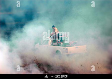 Vigili del fuoco che combattono un piccolo incendio a pennello nella zona di Atlanta con acqua e attrezzature di sicurezza Foto Stock