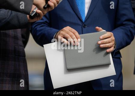 Profondità di campo ridotta (focalizzazione selettiva) dettagli con le mani di un politico che effettua una conferenza stampa. Foto Stock