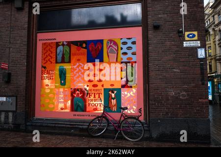 Bicicletta parcheggiata sotto la pioggia fuori dal magazzino Stockmanns, Helsinki, Finlandia, cupa serata estiva buia Foto Stock