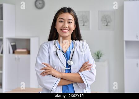 Ritratto vita fino di un medico asiatico femmina o studente medico che tiene la mano incrociata Foto Stock