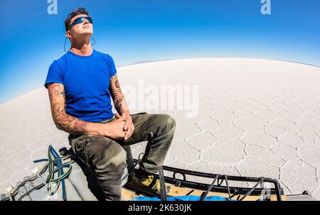 Giovane viaggiatore solista prendere pausa relax al Salar de Uyuni saline nel deserto sudamericano boliviano - Avventura wanderlust concetto sul famou del mondo Foto Stock