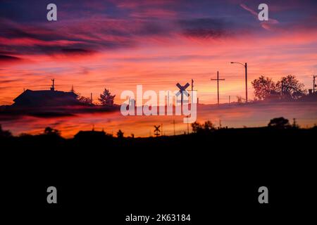 Antonito, Colorado, doppia esposizione di una ferrovia che attraversa all'alba, fuoco cielo mattina Foto Stock