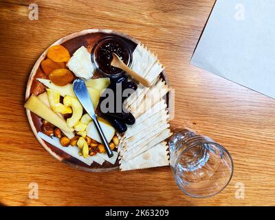 Un piatto di formaggi con cracker, uva e marmellata Foto Stock