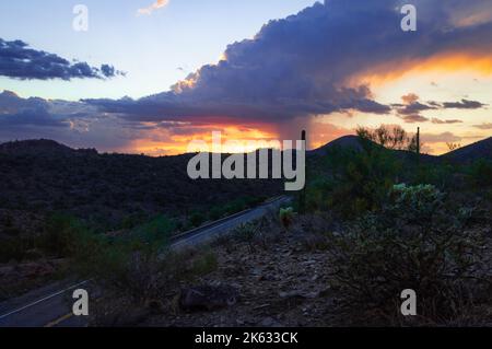 Vista al tramonto della strada e delle montagne al Lake Pleasant Regional Park, a Maricopa, Arizona. Foto Stock