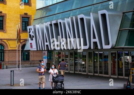 Coppia con bambino al di fuori del reparto maternità di Gregorio Marañón Hospitla, Madrid, Spagna, grande segno 'Maternidad' Foto Stock