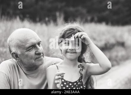 Ritratto di nonno e nipote sorridenti al parco Foto Stock