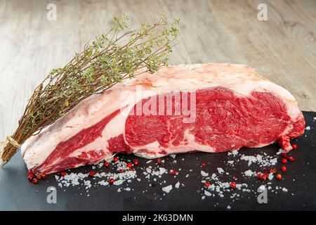 Entrecote crudo con spezie sul tavolo della cucina Foto Stock