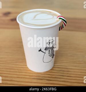 Holiday Coffee latte drink con design in schiuma di latte, tazza Snowman e canna da zucchero Foto Stock