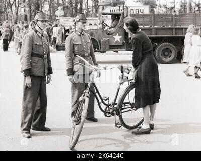 Fotografia della seconda guerra mondiale d'epoca - la polizia tedesca ha interrogato una donna nei giardini del Reichstag di Berlino in un'azione contro i mercanti neri. Agosto 1945 Foto Stock