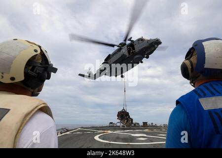 MAR CINESE MERIDIONALE (OTT 2, 2022) Un elicottero canadese Sikorsky CH-148 Cyclone fornisce forniture al ponte di volo durante un rifornimento in mare con il cacciatorpediniere missilistico guidato di classe Arleigh Burke USS Higgins (DDG 76) mentre conduce operazioni nel Mar Cinese Meridionale, ottobre 2. Higgins sta partecipando a esercitazioni multilaterali nel Mar Cinese Meridionale a sostegno dello schieramento della forza di autodifesa marittima giapponese Indo-Pacific, insieme alla Royal Canadian Navy. Esercizi multilaterali di routine come questo rafforzano l'interoperabilità e il nostro reciproco impegno a mantenere un Indo-Pacif libero e aperto Foto Stock