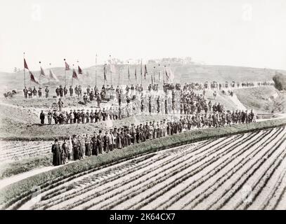 Fotografia d'annata del XIX secolo: Giappone (?) c.1880's - immagine insolita di una grande folla di persone in attesa su una collina, tutti indossando cappelli e striscioni. Foto Stock