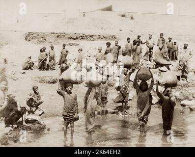 19 ° secolo vintage fotografia: Le donne che riempiono le loro pentole d'acqua dal fiume Nilo, Egitto, circa 1890. Monolocale Zangaki. Foto Stock