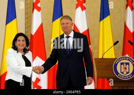 Bucarest, Romania. 11th Ott 2022. Il presidente rumeno Klaus Iohannis (R) si scrolla le mani con il presidente georgiano Salome Zourabichvili dopo una conferenza stampa congiunta al Palazzo Presidenziale di Cetroceni a Bucarest, in Romania, il 11 ottobre 2022. Martedì scorso il presidente rumeno Klaus Iohannis e il suo omologo georgiano Salome Zourabichvili hanno firmato una dichiarazione congiunta che istituisce un partenariato strategico tra i due paesi. Credit: Cristian Cristel/Xinhua/Alamy Live News Foto Stock