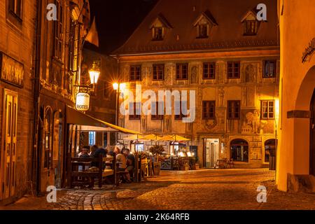 Vista notturna di una vecchia casa cittadina e di un ristorante con persone irriconoscibili a Cesku Krumlov, Boemia del Sud, Repubblica Ceca. Foto Stock