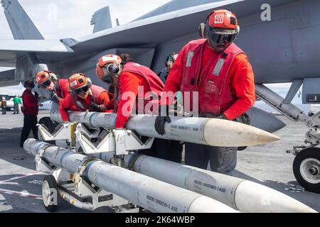 Oceano Atlantico, Spagna. 11 ottobre 2022. I marinai della Marina militare statunitense caricano MISSILI aria-aria AIM-120 su un aereo da combattimento F/A-18E Super Hornet a bordo della nave USS Gerald R. Ford, nave principale della Ford Class, 11 ottobre 2022 vicino alla Spagna. Credito: MC2 Jackson Adkins/USA Navy Photo/Alamy Live News Foto Stock