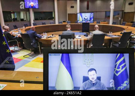 Bruxelles, Belgio. 11th Ott 2022. Il presidente ucraino Volodymyr Zelensky è visto sugli schermi mentre parla mentre il presidente del Consiglio europeo Charles Michel (2nd-L) partecipa alla riunione virtuale dei leader del Gruppo dei sette (G7) e dell'Ucraina tramite videoconferenza, a Bruxelles, in Belgio, martedì, ottobre. 11, 2022. Il presidente ucraino Volodymyr Zelensky ha chiesto ai leader del Gruppo dei sette (G7) paesi di un maggiore sostegno alle capacità di difesa aerea 'scudo aereo', mentre G7 ha promesso di continuare a sostenere Kyiv per 'finchè ci vuole'. Photo by European Union/UPI Credit: UPI/Alamy Live News Foto Stock