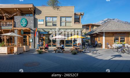 Banff, Alberta, Canada – 07 ottobre 2022: Le persone si siedono ai tavoli da picnic all'esterno di una panetteria del centro Foto Stock