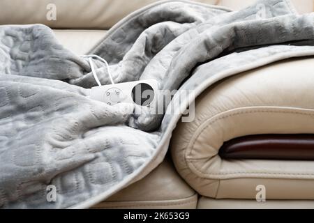 coperta elettrica con controller su un divano Foto Stock