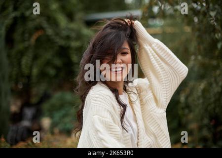 Ritratto di bella donna asiatica kazako brunette con un sorriso affascinante camminando all'aperto Foto Stock