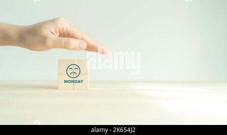 Evitate di sentirvi giù sul concetto di lunedì blu. Proteggere i cubi di legno con un volto triste. Lunedì blues, stanco e paura di lavoro di routine in ufficio, depressione o. Foto Stock