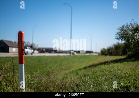 Posto marcatore per la linea ottica sotterranea di internet lungo un fosso stradale. Foto Stock