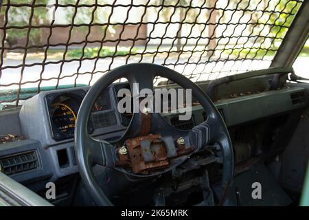 vecchio veicolo militare rotto con barre sul finestrino anteriore, la vettura dopo il passaggio di ostilità, auto Foto Stock