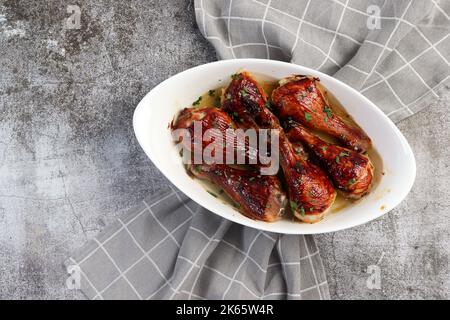 Bastoncini di pollo Hoisin in un piatto da forno bianco su sfondo grigio scuro. Vista dall'alto, disposizione piatta Foto Stock