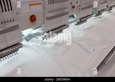 Il ricamo a macchina è un processo di ricamo in cui una macchina da cucire o una macchina da ricamo viene utilizzata per creare motivi su tessuti. Tessile: Industriale Foto Stock