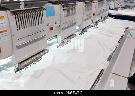 Il ricamo a macchina è un processo di ricamo in cui una macchina da cucire o una macchina da ricamo viene utilizzata per creare motivi su tessuti. Tessile: Industriale Foto Stock