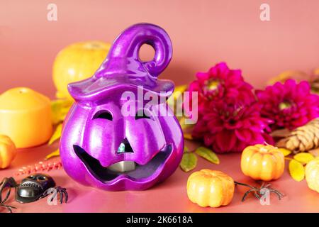 Sfondo creativo di concetto di Halloween. Halloween jack o lanterna con candele brucianti, zucche su uno sfondo marrone chiaro. Foto Stock