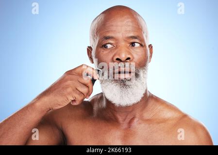 Sbarazzarsi della barba. Un bell'uomo maturo che si posa in studio su uno sfondo blu. Foto Stock