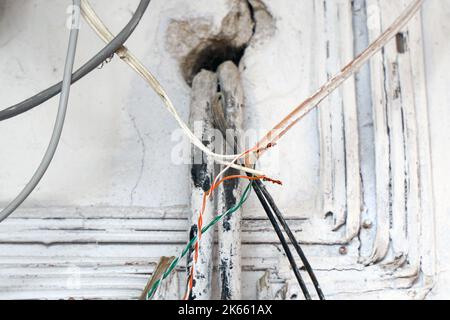 Cablaggio elettrico di pericolo. Filo esposto nel cablaggio elettrico nella parete. Messa a fuoco selettiva Foto Stock