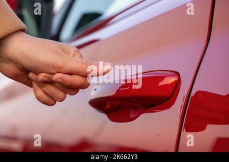 Donna chiude l'auto con un dito, primo piano Foto Stock