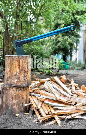 Axe su blocco di taglio legna con bastoni di legno tritati per accendere e accendere fuochi o riscaldamento casa stufa a legna. Foto Stock