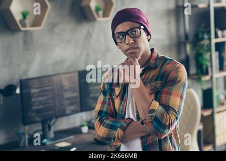 Foto di fresco programmatore medaghe indossare occhiali cappello pensare programma di debagging al chiuso luogo di lavoro workshop casa Foto Stock