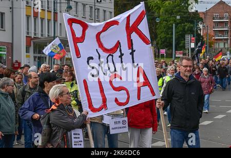 03 ottobre 2022, Brandeburgo, Francoforte (Oder): Molte persone e un cartello con la scritta "PCK anziché USA" sono viste durante una manifestazione di protesta nel centro della città. Anche questo lunedì a Francoforte (Oder) centinaia di persone sono scese in strada per una manifestazione di protesta. L'occasione è stata la crisi energetica, la guerra in Ucraina e la politica di Corona. Con tamburi, fischi, bandiere tedesche e bandiere russe, marciarono per il centro della città il giorno dell'unità tedesca, come ha riferito un reporter del dpa. Ha stimato il numero di partecipanti a circa 2.000. Tra le altre cose, le bandiere hanno letto 'solo la pace è un vic Foto Stock