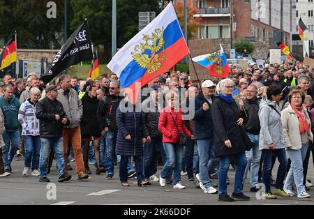 03 ottobre 2022, Brandeburgo, Francoforte (Oder): Molte persone partecipano a una manifestazione di protesta nel centro della città, sventolando, tra le altre cose, le bandiere della Russia. Anche questo lunedì a Francoforte (Oder) centinaia di persone sono scese in strada per una manifestazione di protesta. La causa è stata la crisi energetica, la guerra in Ucraina e la politica di Corona. Con tamburi, fischi, bandiere tedesche e bandiere russe, marciarono per il centro della città il giorno dell'unità tedesca, come ha riferito un reporter del dpa. Ha stimato il numero di partecipanti a circa 2.000. Tra le altre cose, le bandiere leggono 'solo la pace è un vincitore Foto Stock