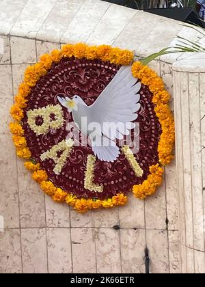 Kuta, Indonesia. 12th Ott 2022. Un arrangiamento floreale con la parola 'Bali' e una 'dove della pace' è visto in un servizio commemorativo per le vittime degli attacchi di Bali 20 anni fa. Il 12 ottobre 2002, le auto bombe a Kuta hanno ucciso 202 persone e ferito molte altre. Solo 88 australiani sono stati uccisi. In occasione dell'anniversario, molte persone hanno deposto fiori e scritto piccole lettere in memoria dei loro cari che sono morti nell'attacco. Credit: Carola Frentzen/dpa/Alamy Live News Foto Stock