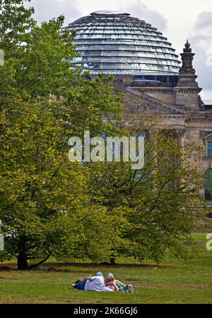 Due persone giacciono sulla Piazza della Repubblica di fronte al Reichstag di Berlino, Bundestag tedesco, distretto governativo, Germania, Berlino Foto Stock