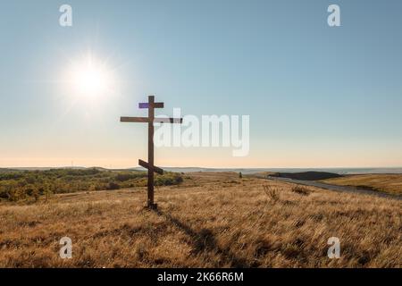 Una croce cristiana sulla collina. Mattina presto all'alba in estate. Alba con cielo blu. Foto di alta qualità Foto Stock