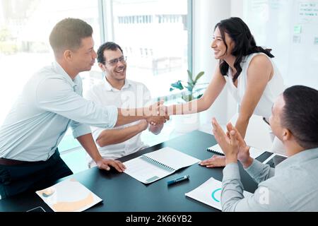 Questa buona notizia vale la pena di festeggiare: Uomini d'affari che si stringono le mani durante una riunione in un ufficio. Foto Stock