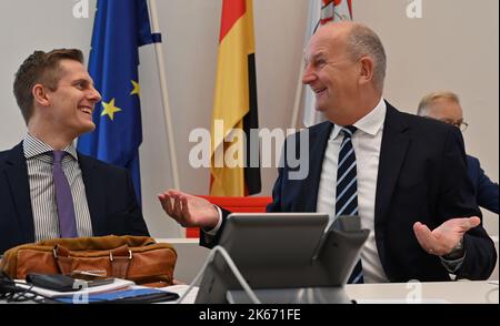 Potsdam, Germania. 12th Ott 2022. Dietmar Woidke (SPD), Ministro Presidente dello Stato di Brandeburgo, parla con Benjamin Grimm (r), Segretario di Stato della Cancelleria di Stato, prima dell'inizio della sessione del parlamento di Stato. Tra le altre cose, i parlamentari discutono della legge di bilancio del governo statale per il 20223/2024, del mercato del lavoro nel Brandeburgo e della raffineria di PCK a Schwedt. Credit: Bernd Settnik/dpa/Alamy Live News Foto Stock