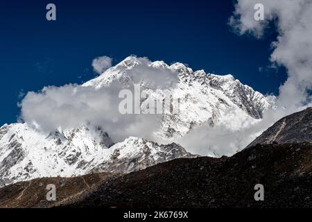 La nuvola e la nebbia si chiariscono sulle vette alte sopra l'Everest Way, trekking fino al campo base del monte Everest Foto Stock