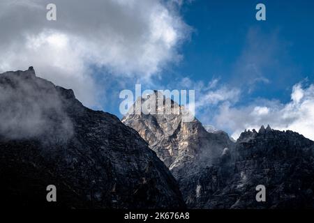 La nuvola e la nebbia si chiariscono sulle vette alte sopra l'Everest Way, trekking fino al campo base del monte Everest Foto Stock