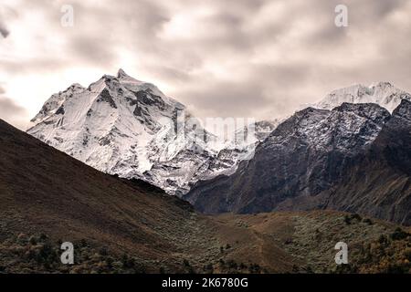 Montagne innevate in lontananza guardando verso la valle, sulla Everest Way, trekking fino al campo base del monte Everest Foto Stock