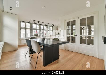 Banchi con stufa e forno situati nella cucina moderna vicino sala da pranzo in casa Foto Stock