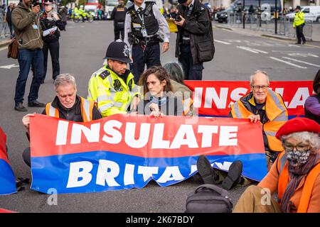 Londra Regno Unito. 12 ottobre 2022 . Gli attivisti climatici di insulate Britain bloccano il parlamento causando disagi al traffico durante una protesta per chiedere al governo britannico di isolare le case in Gran Bretagna. Alcuni attivisti avevano ammanettato e incollato le mani al tarmac. Credit: amer Ghazzal/Alamy Live News. Foto Stock